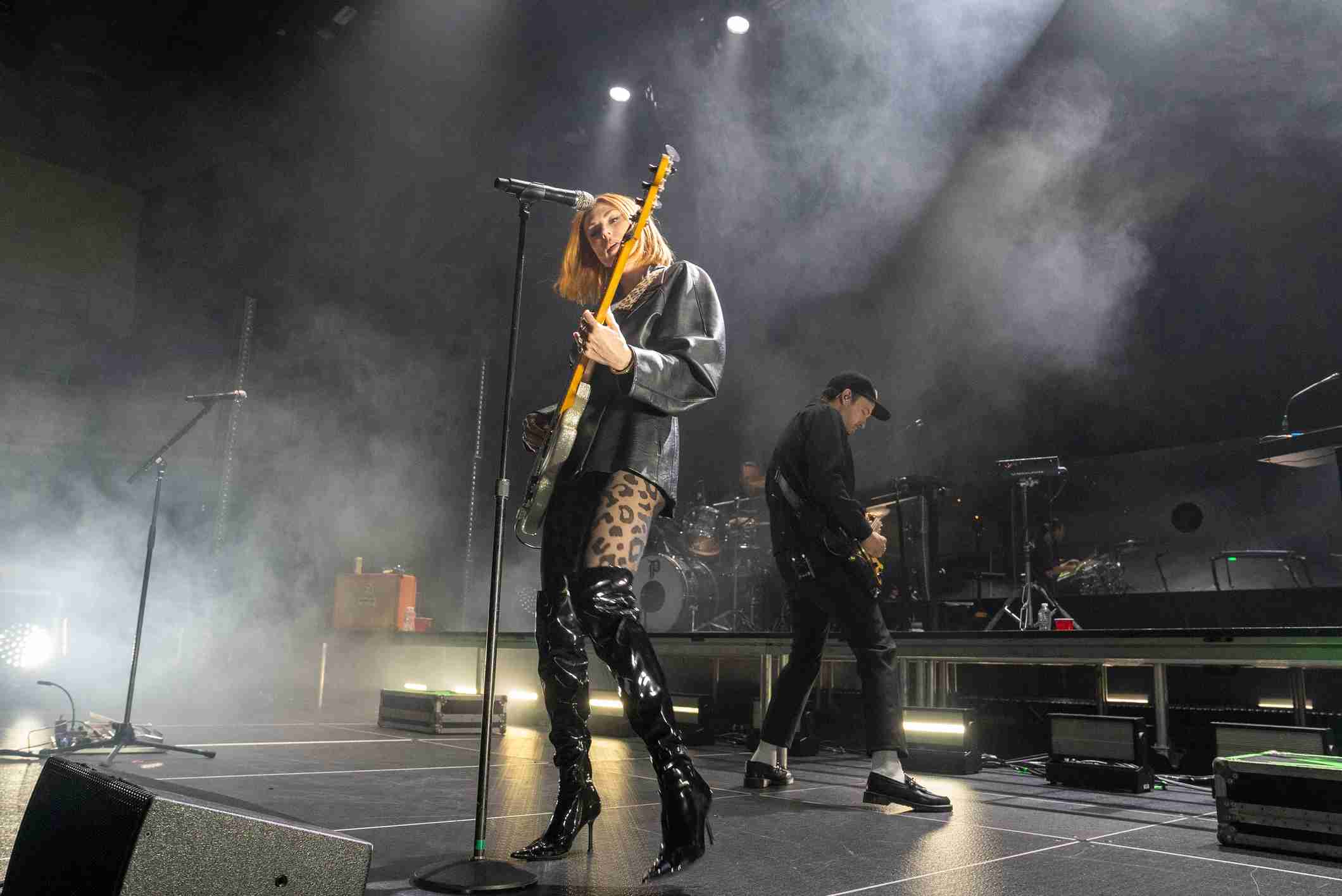 sarah plays bass in the foreground while josh plays guitar in the background